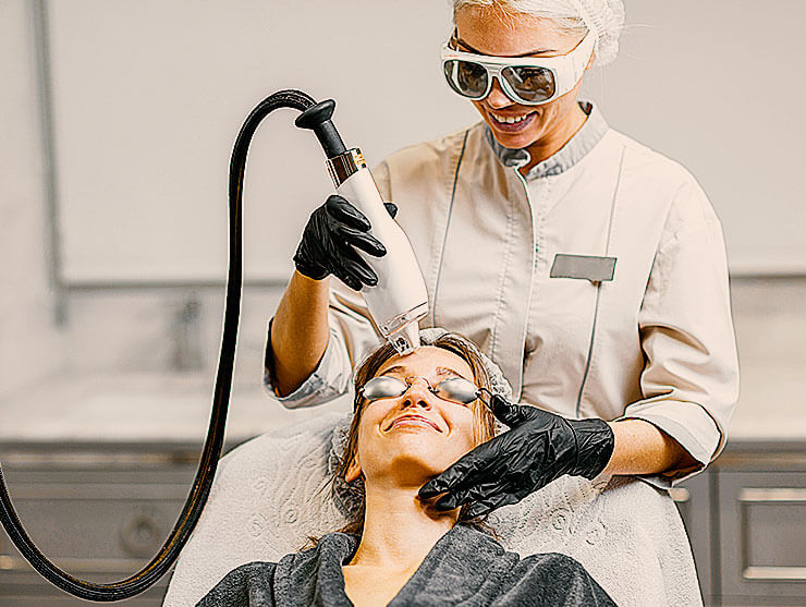 Kundin wird im Kosmetikstudio mit einem Laser behandelt